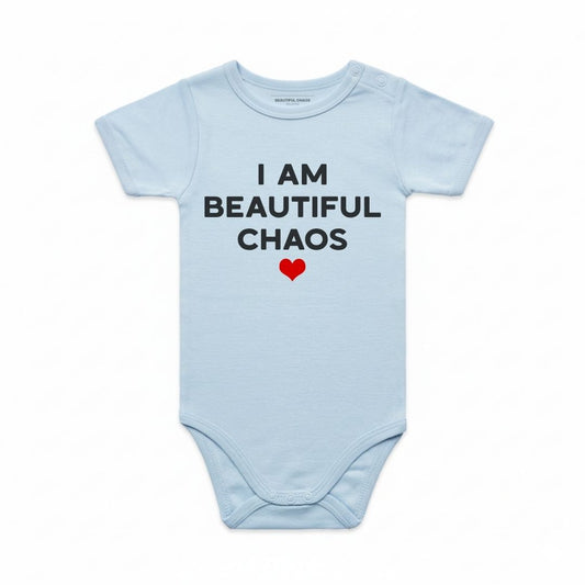 Light blue baby onesie with 'I AM BEAUTIFUL CHAOS' text and a red heart on a white background