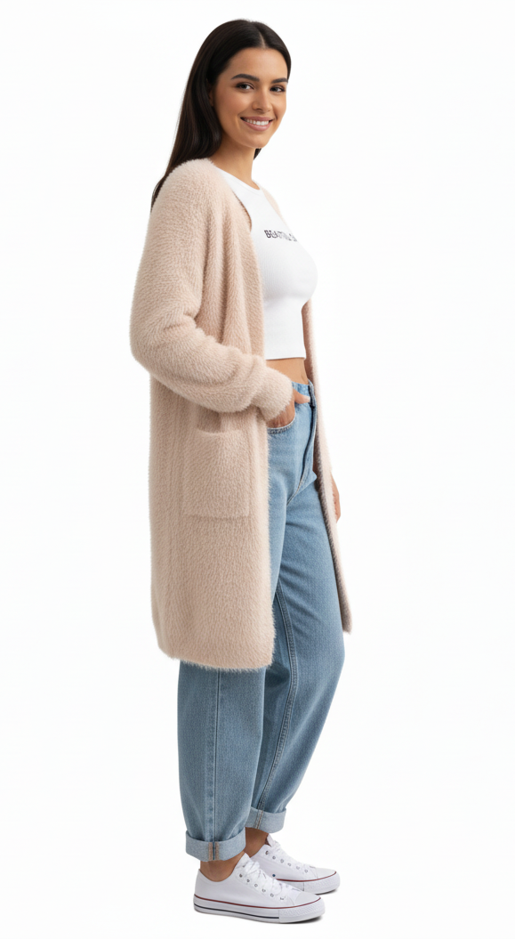 Woman wearing a long beige cardigan, white crop top, and blue jeans on a white background