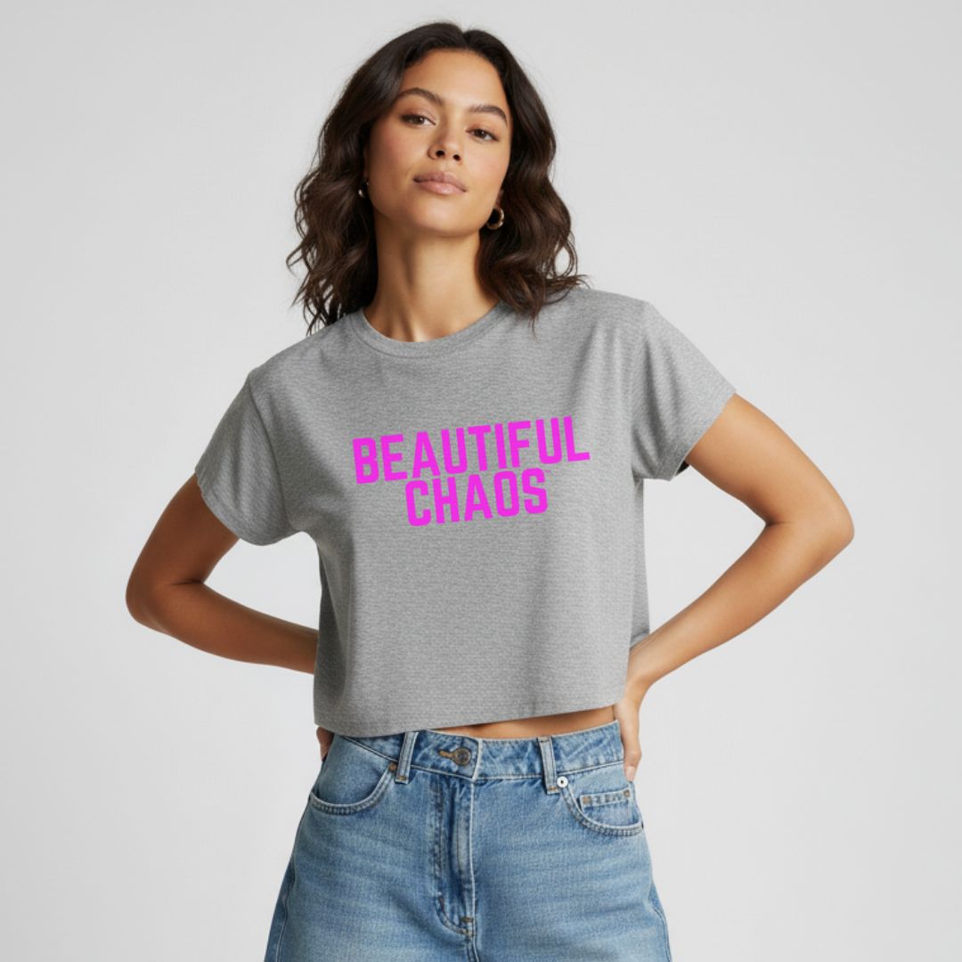 Woman wearing a marle gray t-shirt with 'BEAUTIFUL CHAOS' in pink text on a plain background
