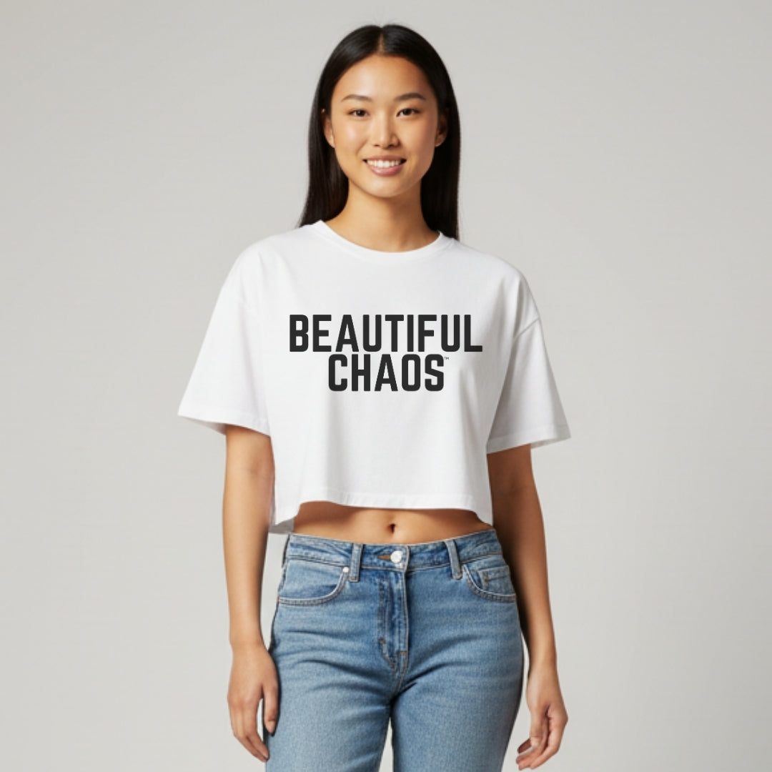 Person wearing a white t-shirt with 'BEAUTIFUL CHAOS' text on a plain background