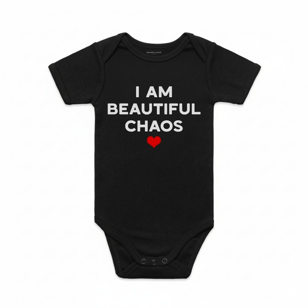 Black baby onesie with 'I AM BEAUTIFUL CHAOS' text and a red heart on a white background