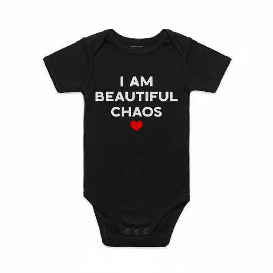 Black baby onesie with 'I AM BEAUTIFUL CHAOS' text and a red heart on a white background