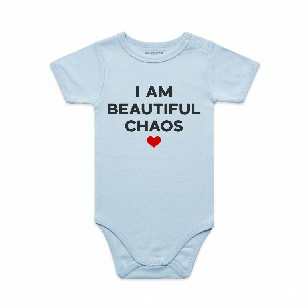 Light blue baby onesie with 'I AM BEAUTIFUL CHAOS' text and a red heart on a white background