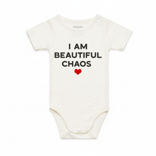 Ecru baby onesie with text 'I AM BEAUTIFUL CHAOS' and a red heart.