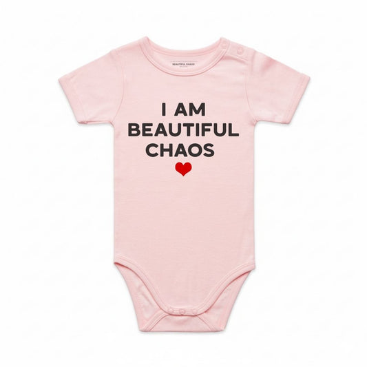 Pink baby onesie with 'I AM BEAUTIFUL CHAOS' text and a heart on a white background