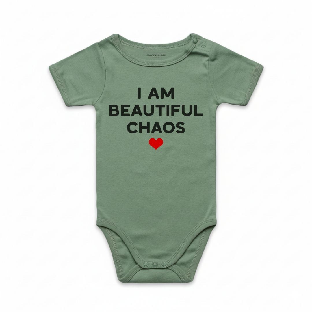 Sage Green baby onesie with text 'I AM BEAUTIFUL CHAOS' and a red heart on a white background