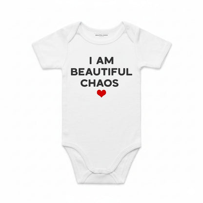 White baby onesie with 'I AM BEAUTIFUL CHAOS' text and a red heart on a white background